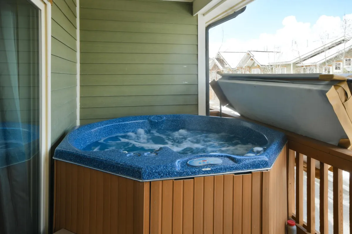 This image features a tranquil indoor hot tub area surrounded by a wooden railing and accented by a lush green wall. The setting is calm and inviting, perfect for relaxing soaks after adventurous days outdoors.