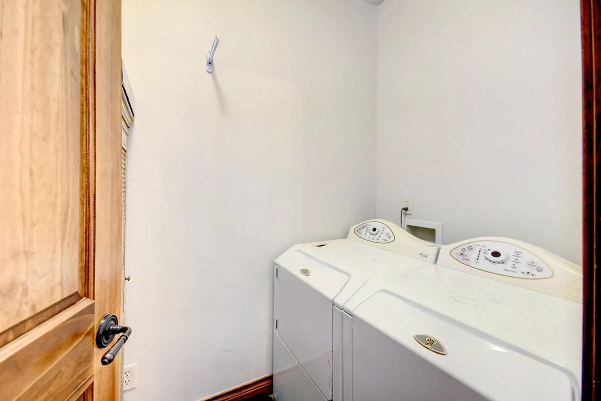 A practical laundry area featuring a modern washer and dryer, with freshly laundered clothes neatly organized, suggesting ease and convenience for extended stays.